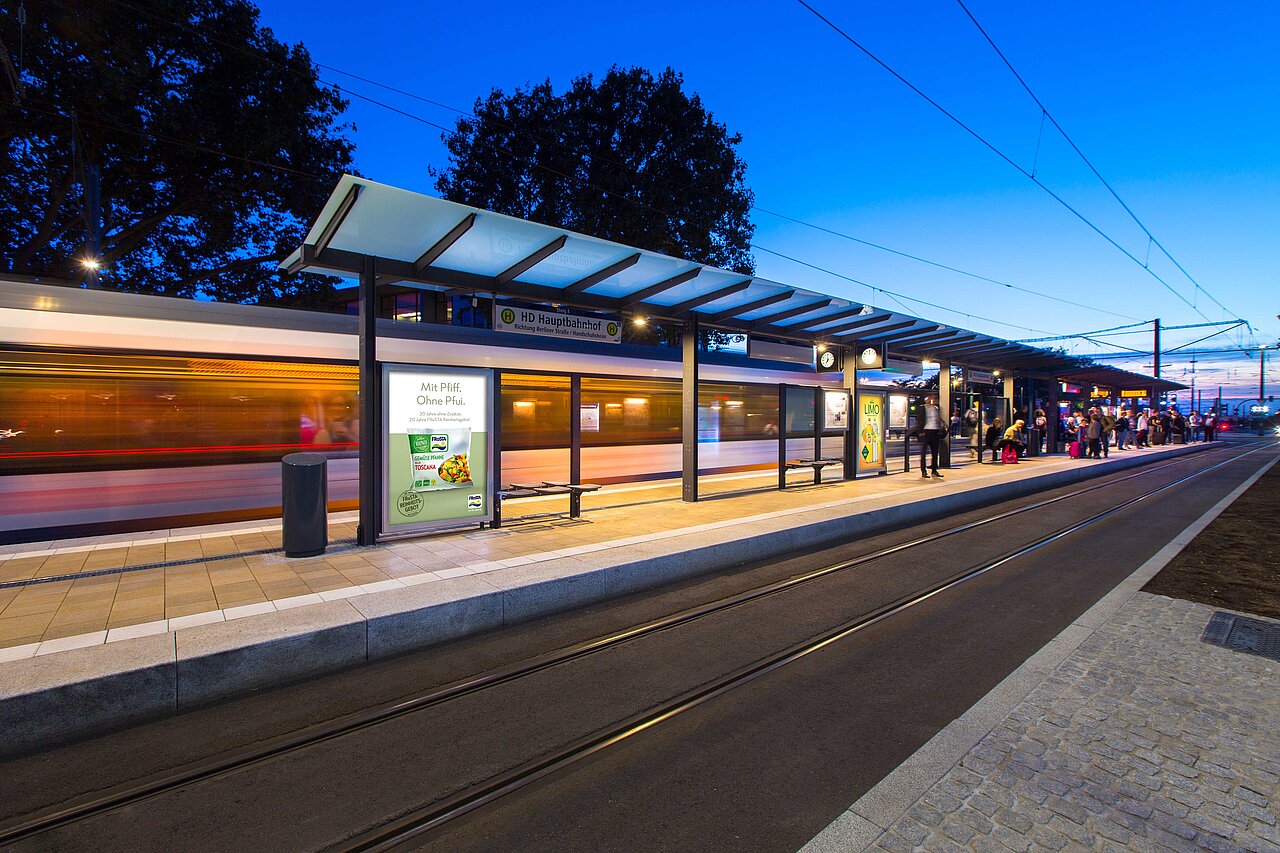 Plakat mit der Aufschrift „Mit Pfiff. Ohne Pfüfi.“ für Citylight-Poster am Bahnhof, ideal für zielgerichtete Werbung an öffentlichen Verkehrsknotenpunkten.
