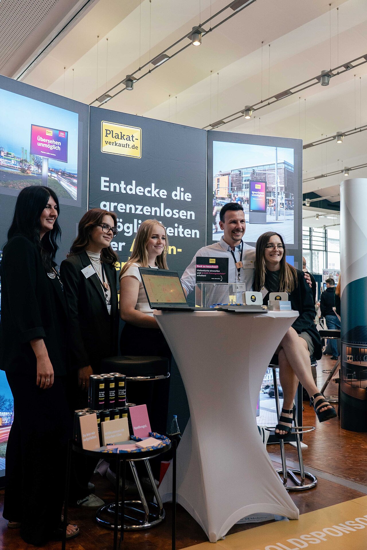 Team von Plakat-verkauft.de steht an einem Messestand und präsentiert das Unternehmen