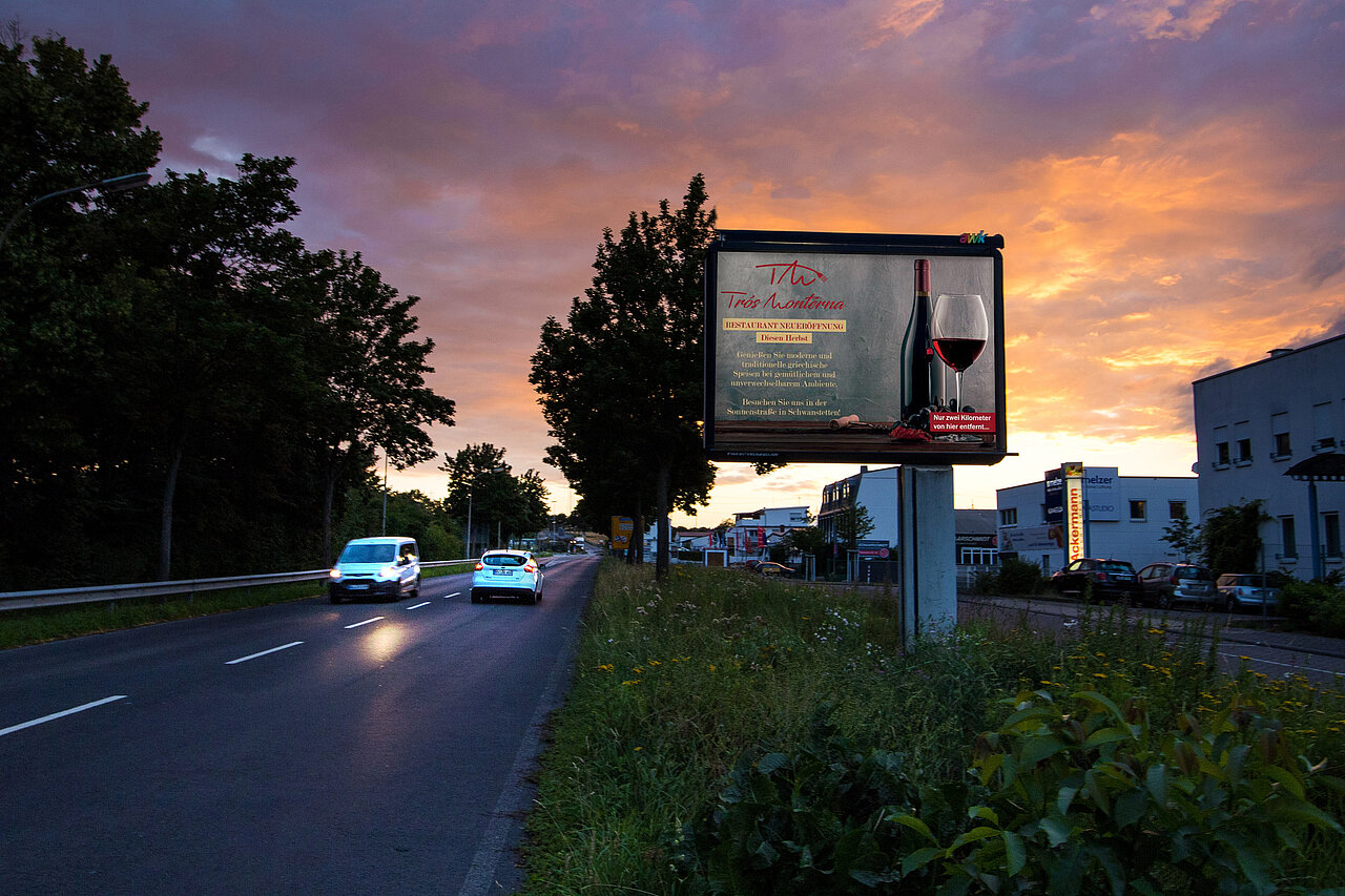 Großplakat mit 9 qm Werbefläche steht an befahrener Straße mit Restaurant-Motiv