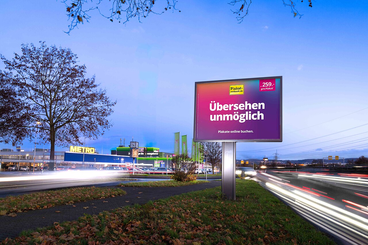 Großes Werbeplakat mit dem Slogan 'Übersehen unmöglich' an einer belebten Straße. Das Plakat ist an einem gut sichtbaren Standort in der Nähe eines großen Einkaufszentrums und zieht die Aufmerksamkeit von Autofahrern und Passanten an.