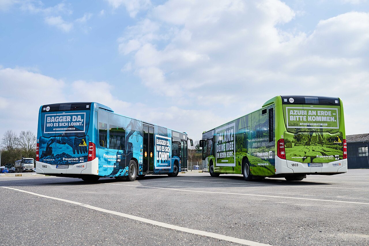 Buswerbung von Frauenrath: Ganzgestaltung auf Bussen mit markanten Botschaften und einer auffälligen Farbgestaltung in Blau und Grün.