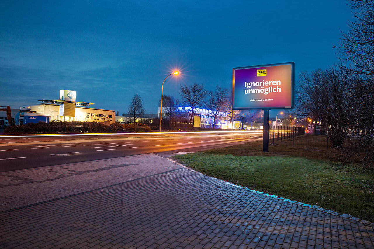 Digitales Großplakat mit der Aufschrift „Ignorieren unmöglich“ an einer gut befahrenen Straße bei Nacht, ideal für aufmerksamkeitsstarke digitale Außenwerbung.