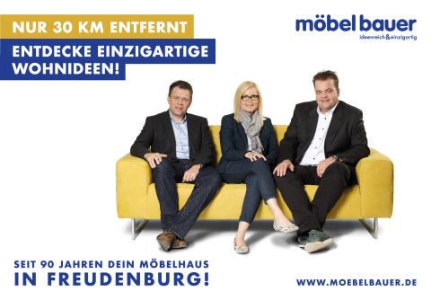 Werbeplakat von Möbel Bauer: Drei Personen sitzen auf einem gelben Sofa. Text: „Entdecke einzigartige Wohnideen – nur 30 km entfernt“. Möbelhaus in Freudenburg mit 90-jähriger Geschichte.